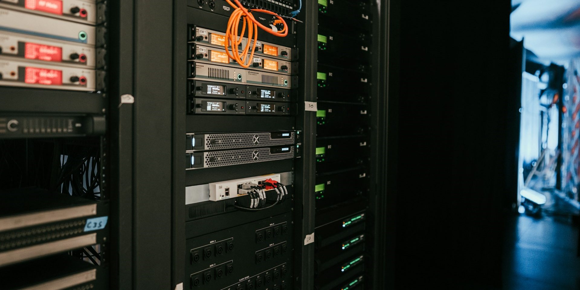 Serverkast met netwerkapparatuur en oranje bekabeling, typerend voor professionele hosting zoals bij Vimexx