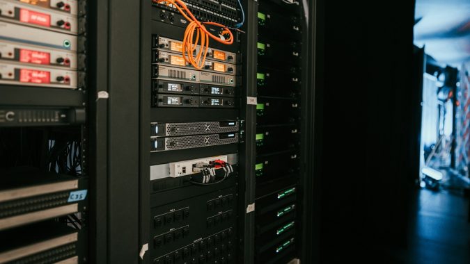 Serverkast met netwerkapparatuur en oranje bekabeling, typerend voor professionele hosting zoals bij Vimexx