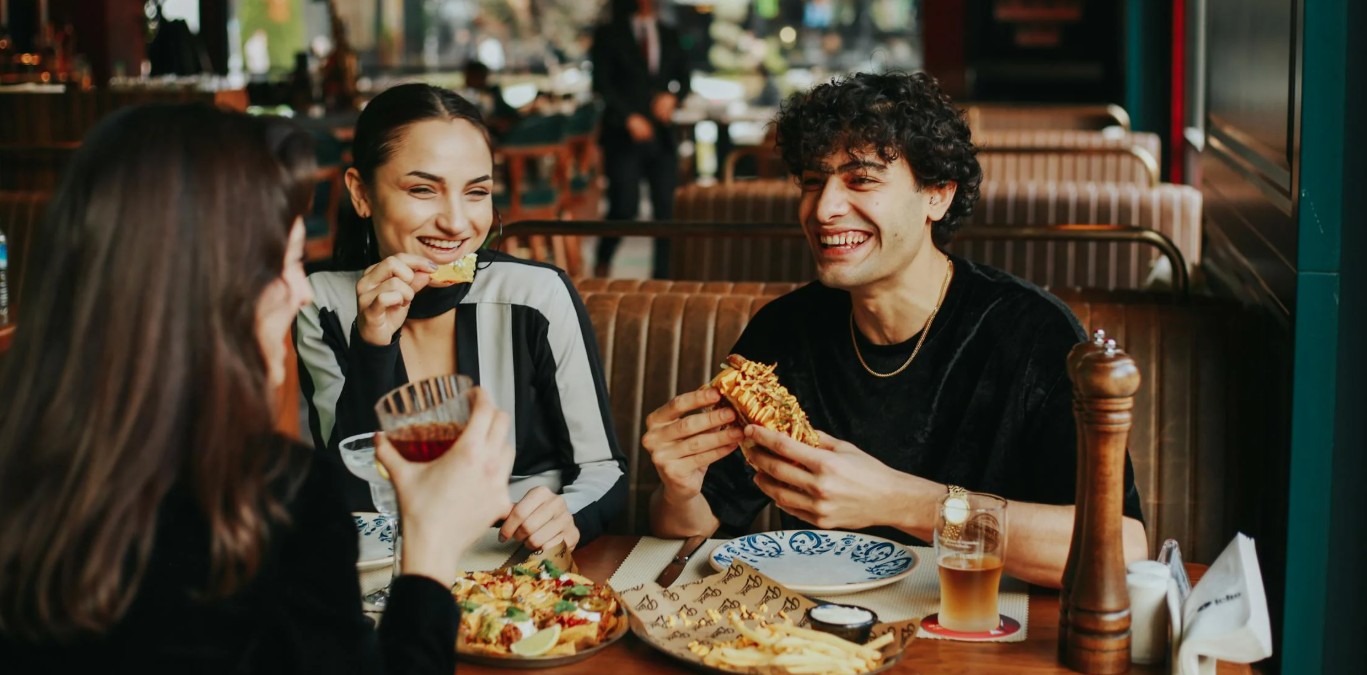 Vriendengroep lacht en geniet van streetfood in restaurant met Turkse mediterrane keuken
